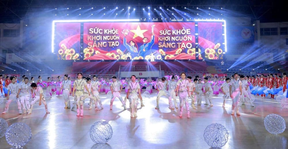 Vũ đoàn áo trắng bạc nhảy trước màn LED chữ Sức khỏe khơi nguồn sáng tạo, quả cầu đèn trên sàn