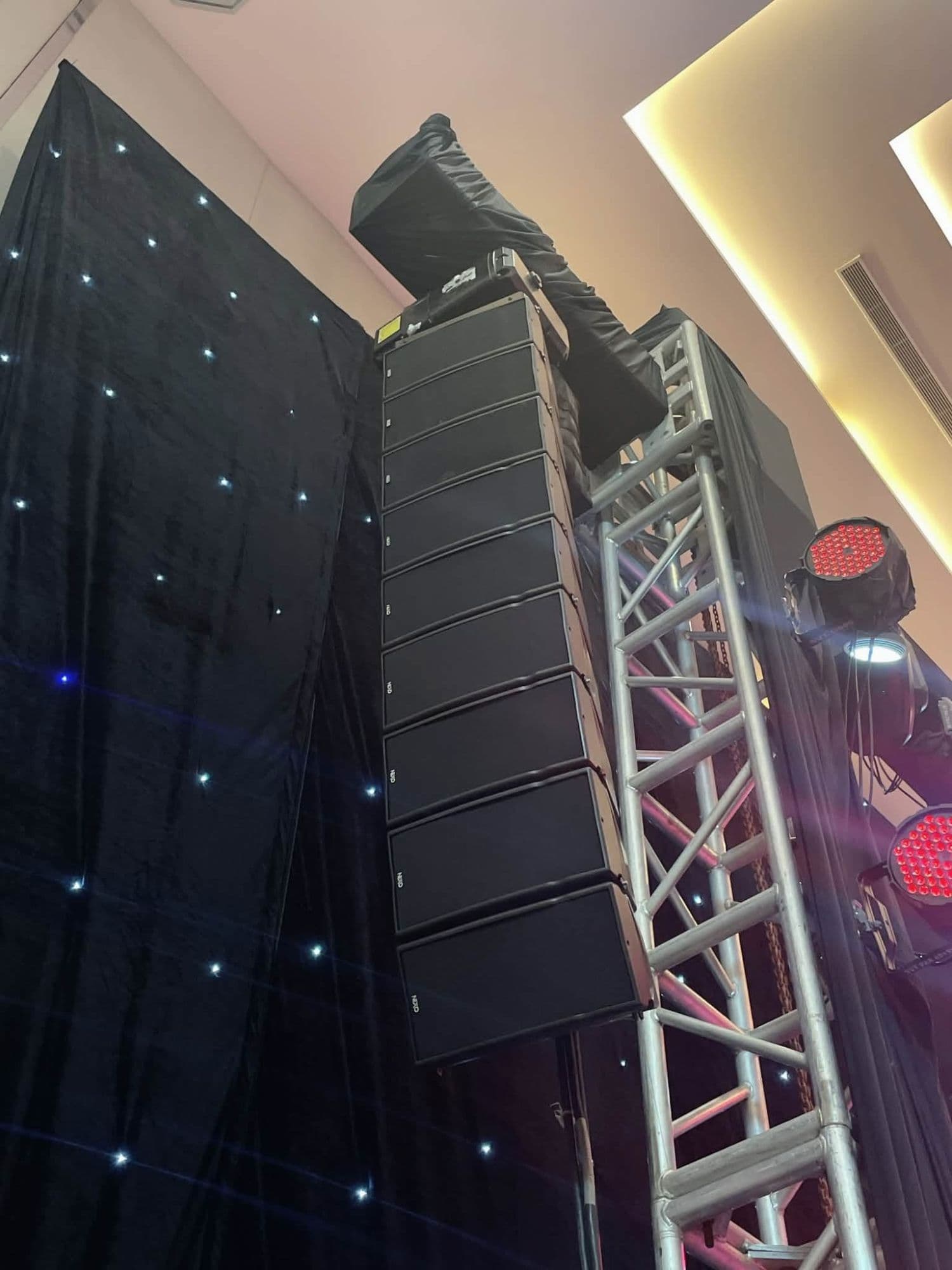 Cụm line array NEXO GEO M6 chín thùng của BOS Entertainment treo trên cột truss cạnh phông sao tại sự kiện trong nhà