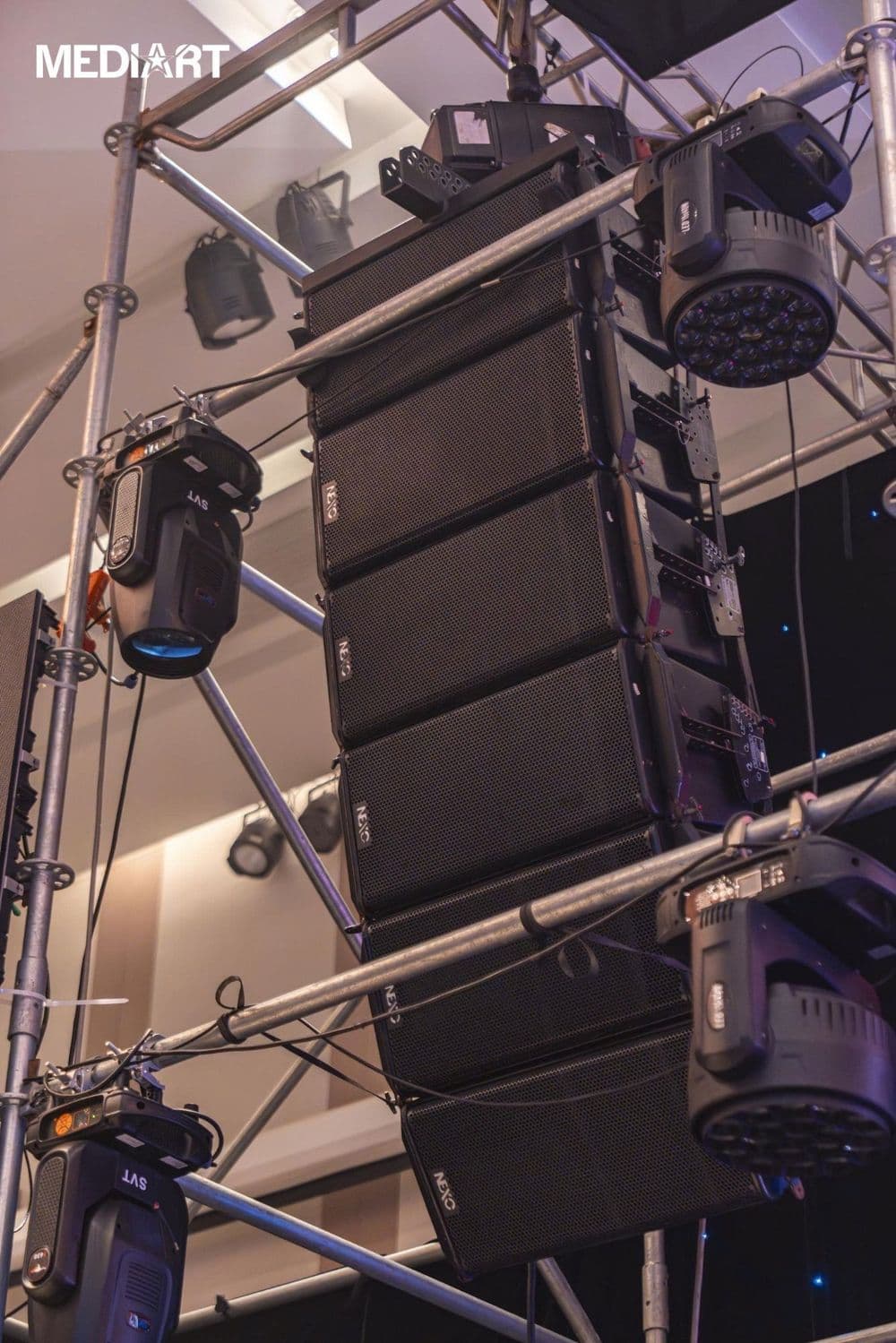 Dàn line array NEXO GEO S12 sáu thùng treo trên khung truss cùng đèn moving head tại sự kiện trong nhà do BOS Entertainment thực hiện