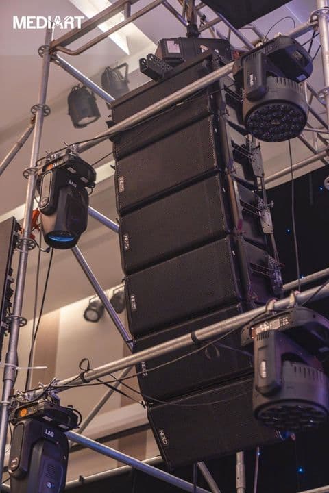 Dàn line array NEXO GEO S12 sáu thùng treo trên khung truss cùng đèn moving head tại sự kiện trong nhà do BOS Entertainment thực hiện