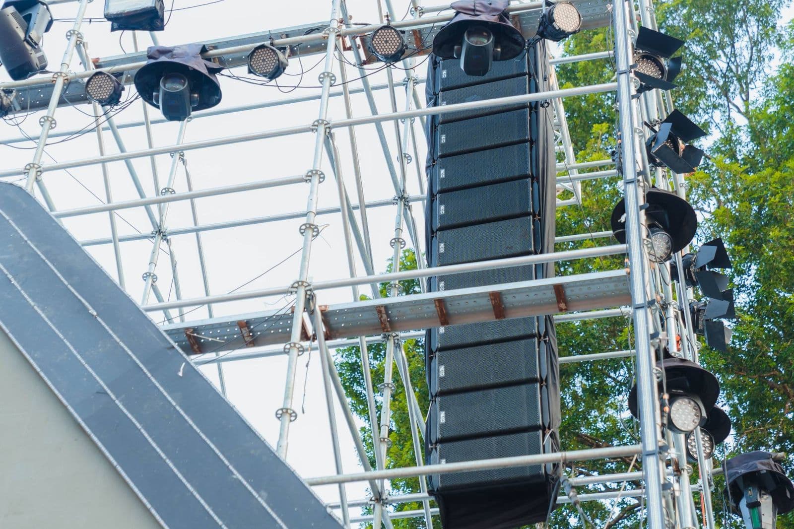 Dàn loa line array NEXO nhìn từ dưới lên, treo dọc cột giàn cùng hệ đèn sân khấu