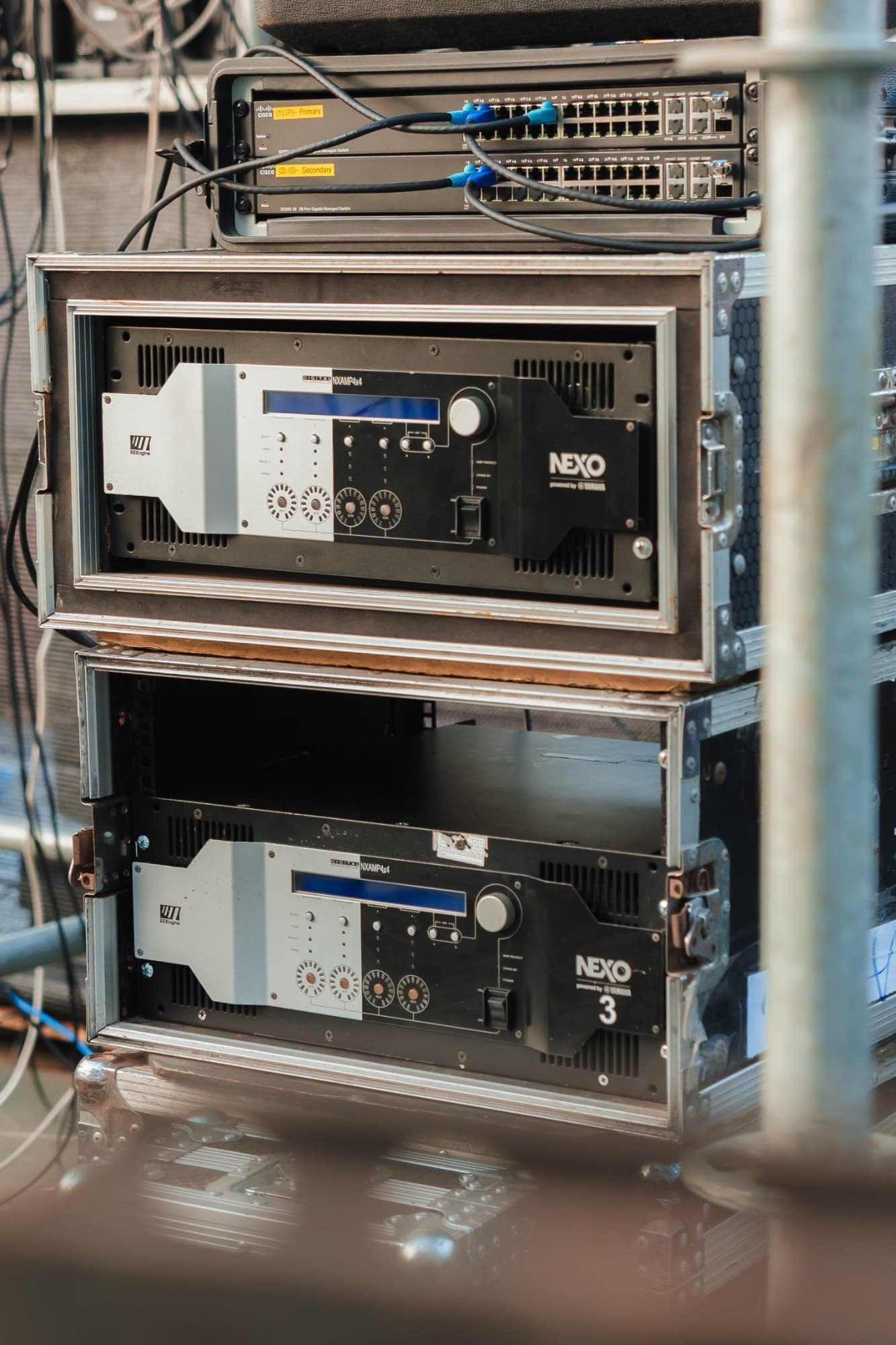 Tủ rack khuếch đại NEXO NXAMP4x4 tại Đêm hội Thành Tuyên 2026, phía trên là hai bộ chuyển mạch Cisco dán nhãn Primary và Secondary