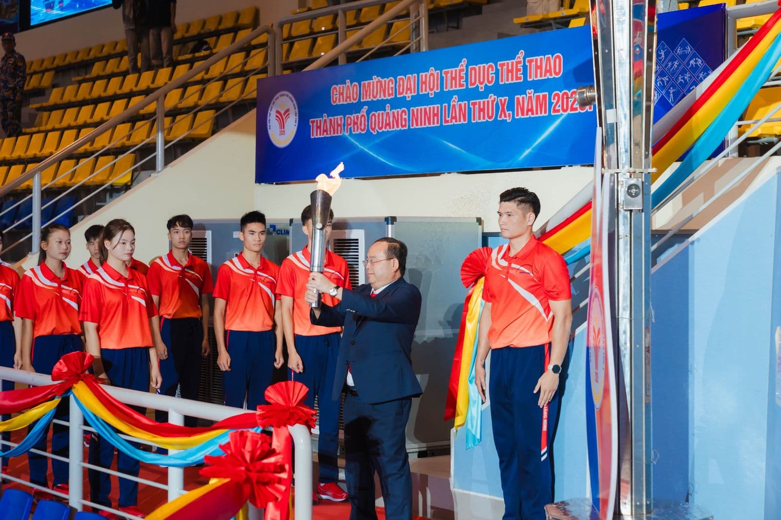 Nghi thức châm đuốc thắp đài lửa Đại hội TDTT Quảng Ninh lần thứ X, các vận động viên đứng bên cạnh