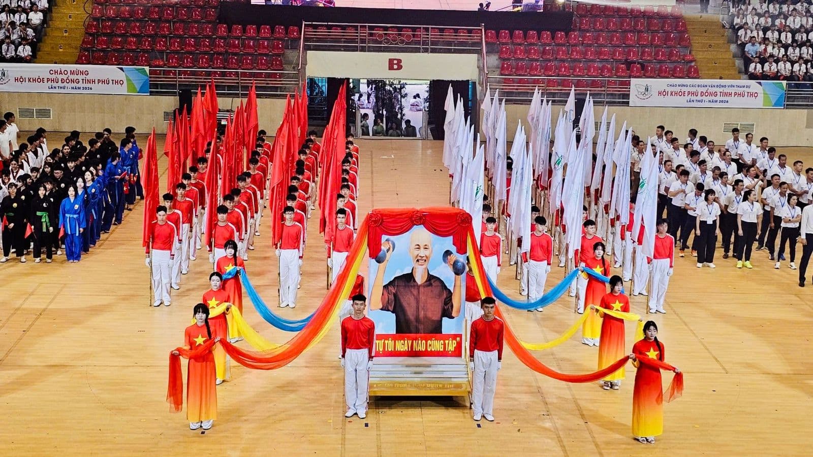Khối mang ảnh Bác Hồ tập thể dục với dòng chữ Tự tôi ngày nào cũng tập giữa hai khối cờ