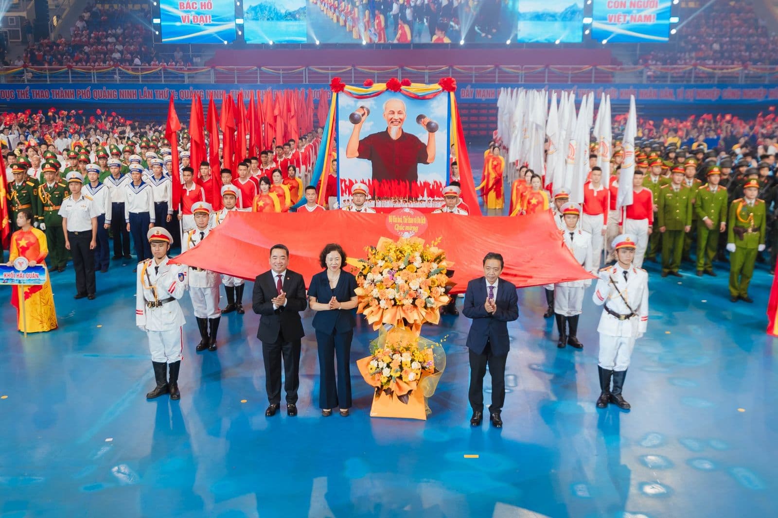 Đại biểu tặng lẵng hoa chúc mừng Đại hội trước khối nghi trượng và quốc kỳ trên sàn nhà thi đấu